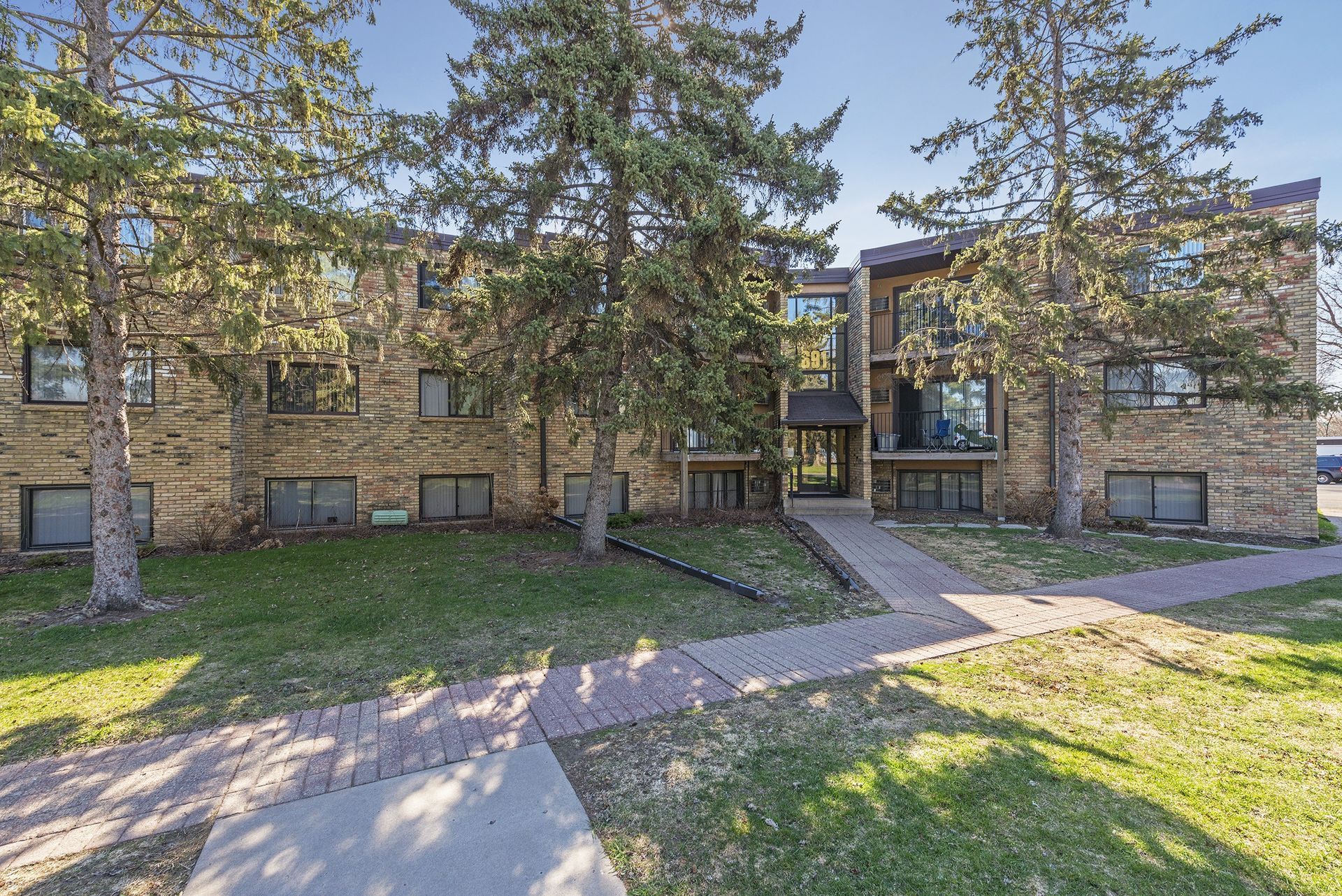 A large brick apartment building with trees in front of it.