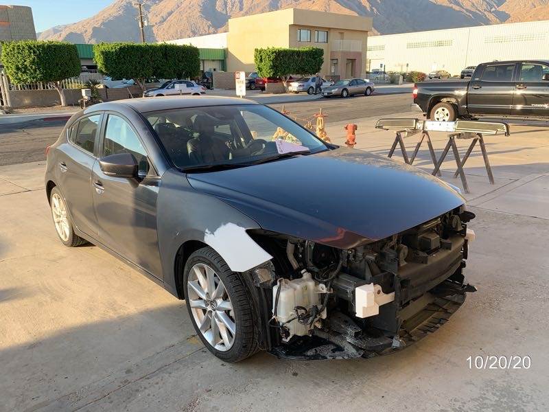 A damaged car is parked in a parking lot.