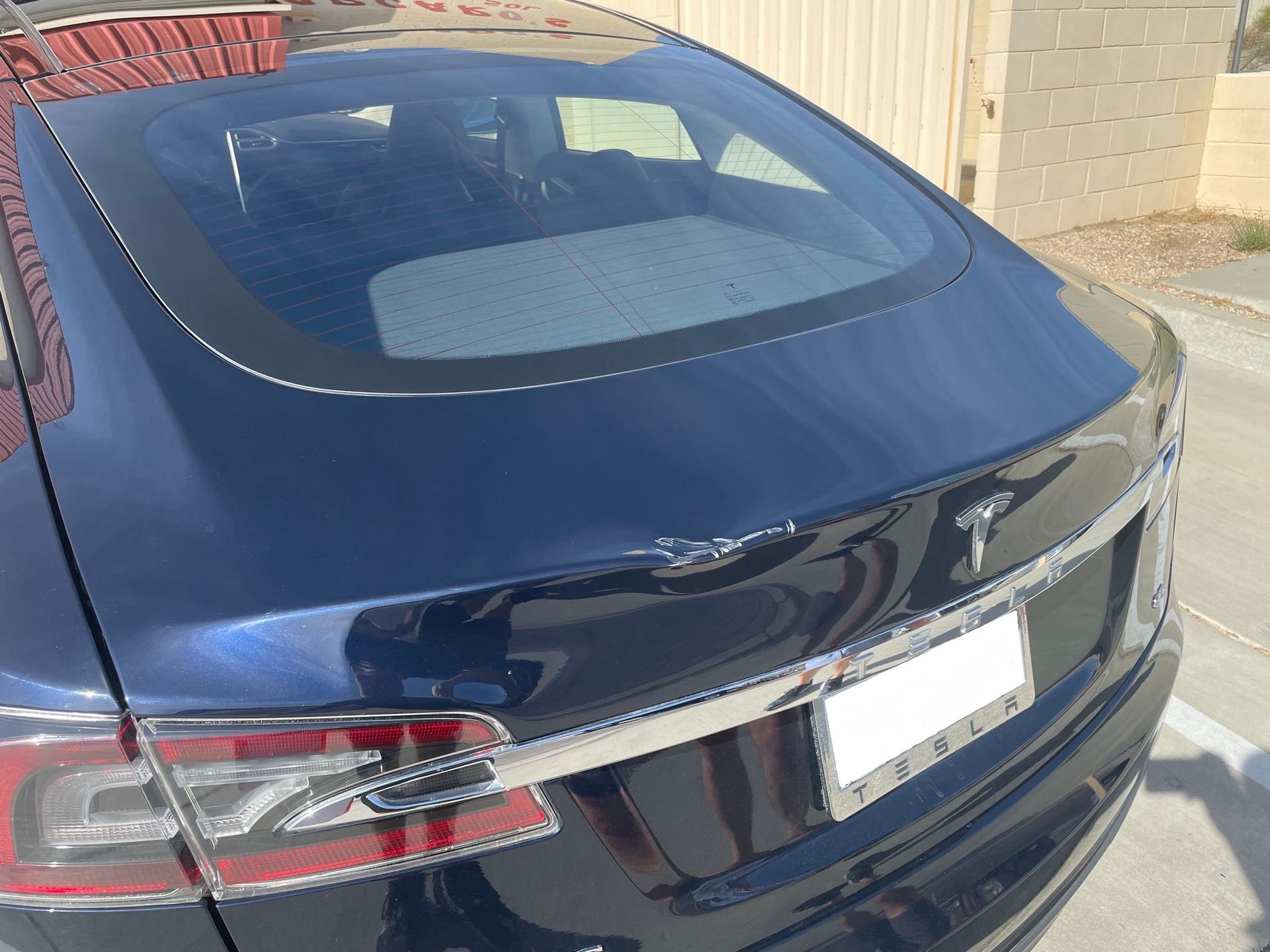 A black tesla model s is parked on the side of the road
