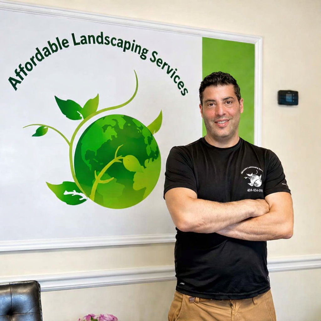 Man standing with arms crossed in front of an Affordable Landscaping Services banner.