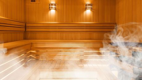 A wooden sauna with smoke coming out of it.