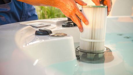 A person is cleaning a filter in a hot tub.