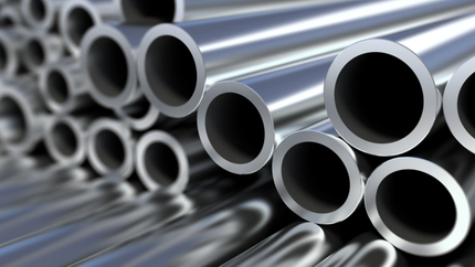 Shiny metal pipes stacked together.