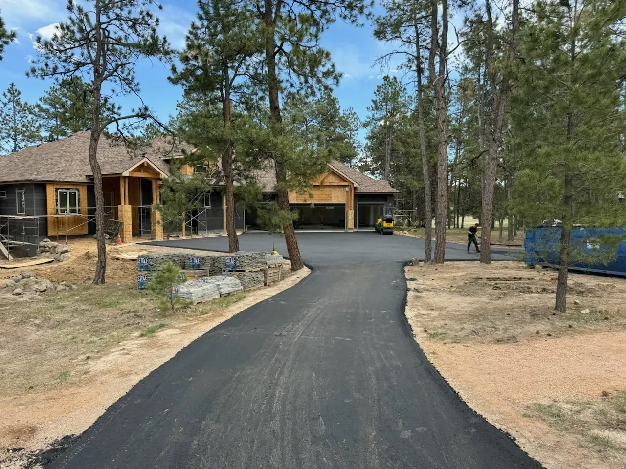 A driveway leading to a house surrounded by trees