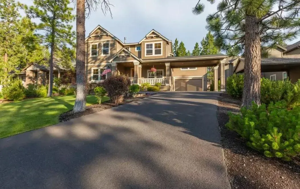 a large house with a driveway leading to it is surrounded by trees .
