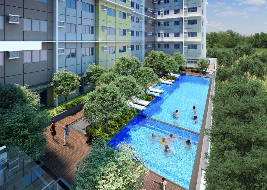 A group of people are swimming in a large swimming pool in front of a building.