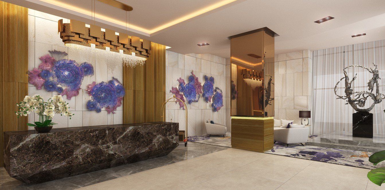 A lobby with a large marble counter and a chandelier hanging from the ceiling.