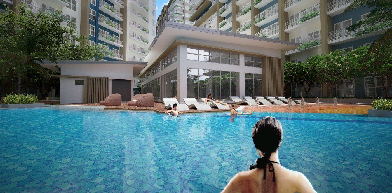 A woman is sitting in a swimming pool in front of a building.