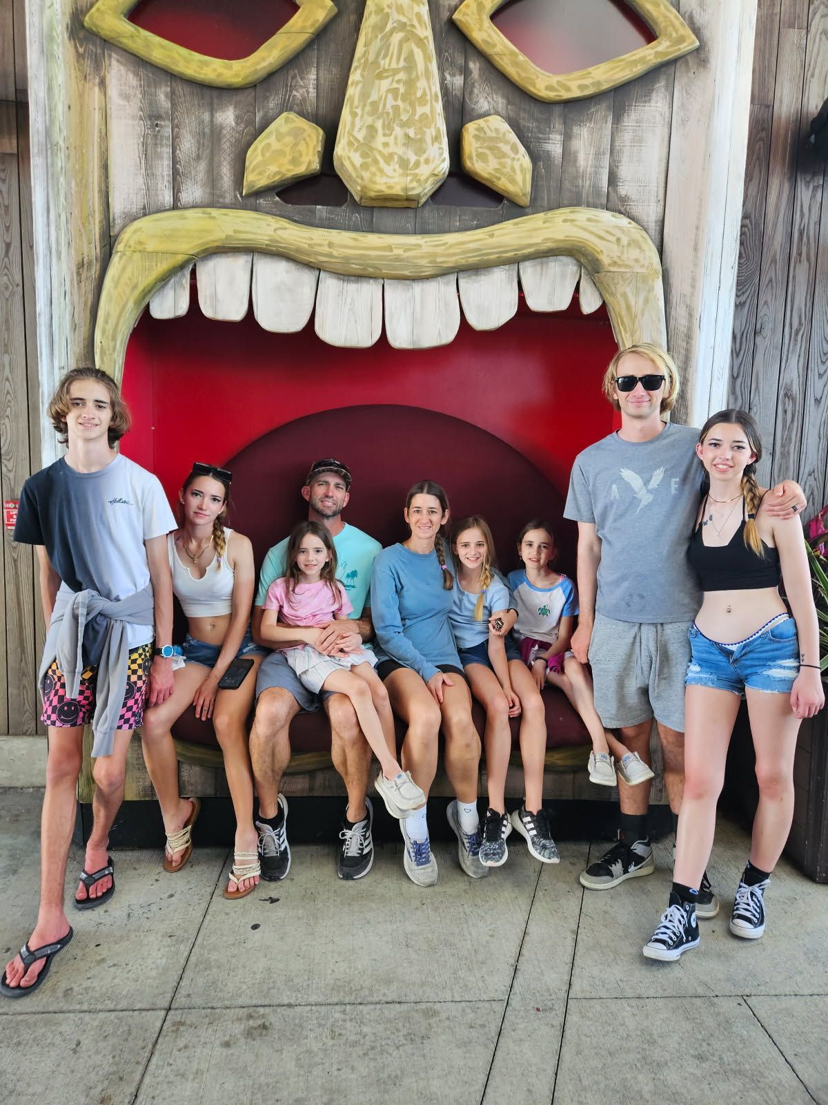 A brown puppy is laying on a pink and white chair.