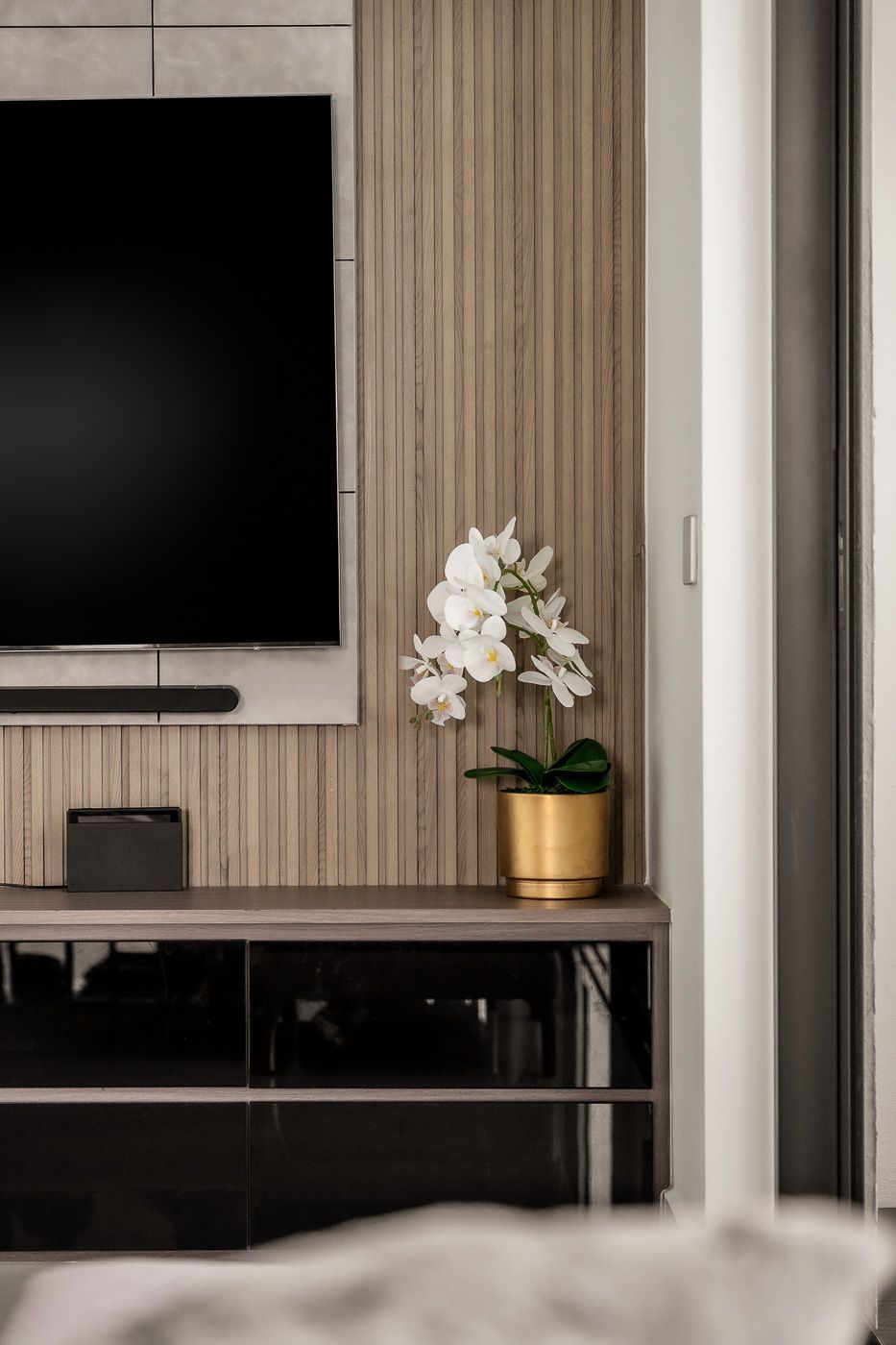 Image 32: A living room with a tv and a potted plant on a table.