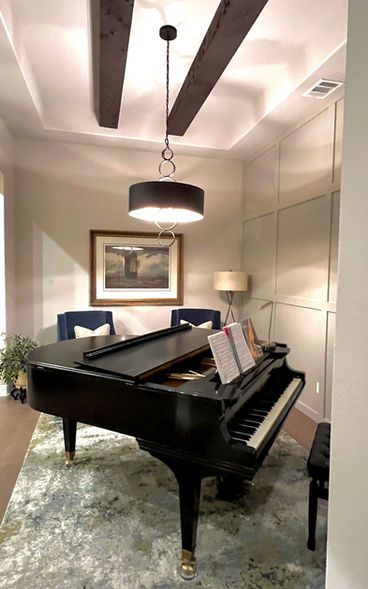A piano is sitting in a living room next to a couch.