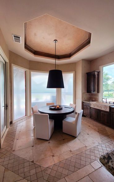 A dining room with a round table and white chairs