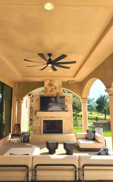 A living room with a fireplace and a ceiling fan