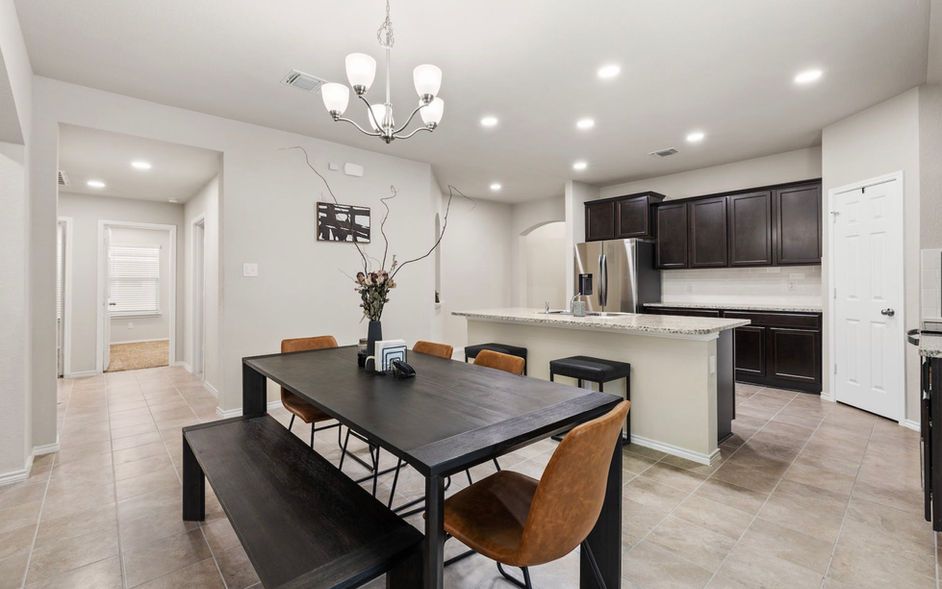 A dining room table with chairs and a bench in a kitchen.