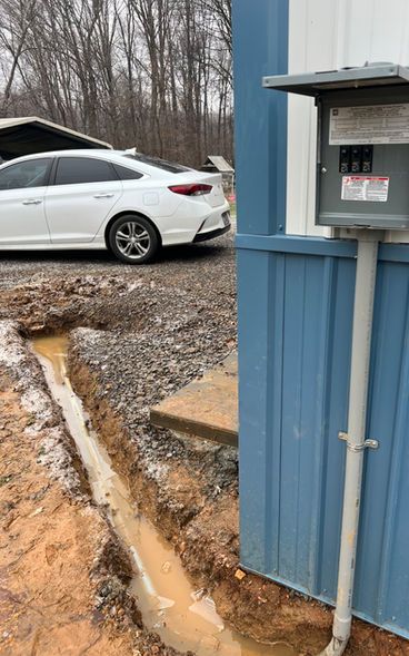 A white car is parked next to a blue building.