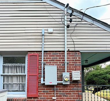 A house with a brick wall and a red shutter on the window.