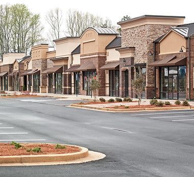 A row of stores are lined up on the side of a street.