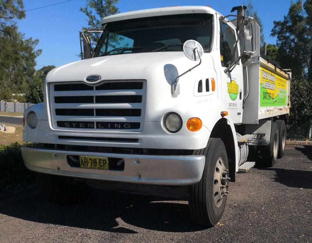 A Sterling Dump Truck is Parked on the Side of the Road — Truck Training and Assessments In Umina Beach, NSW