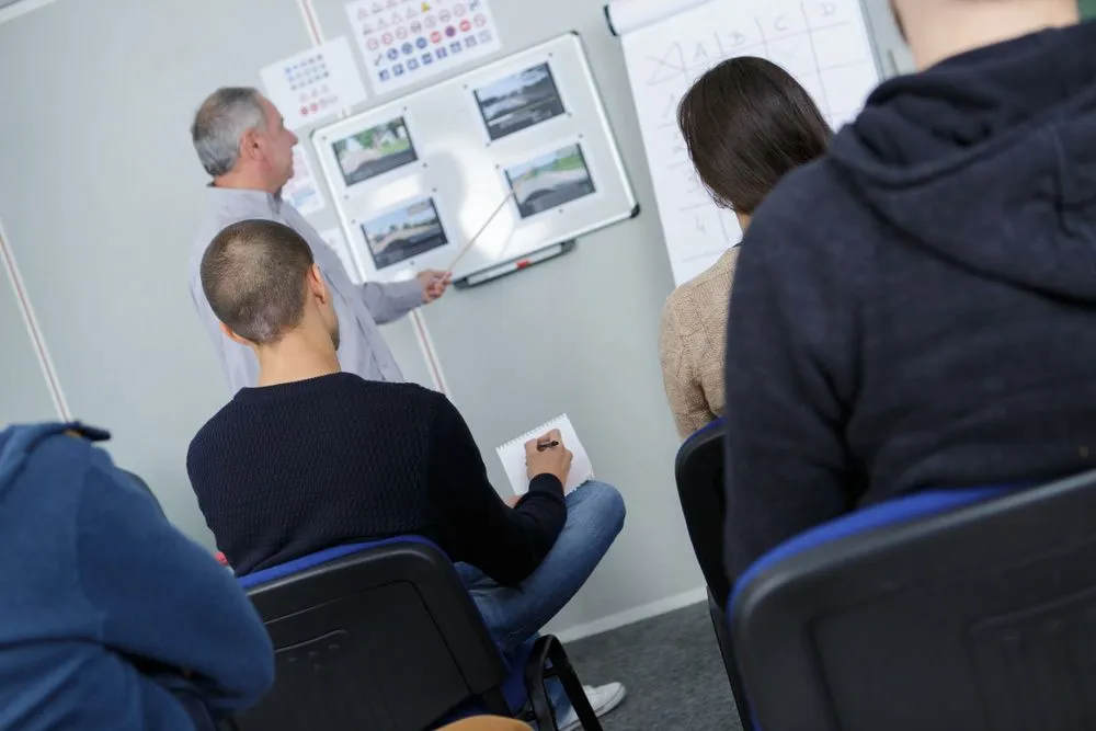 A Man is Giving a Presentation to a Group of People in a Classroom — Truck Training and Assessments In Umina Beach, NSW