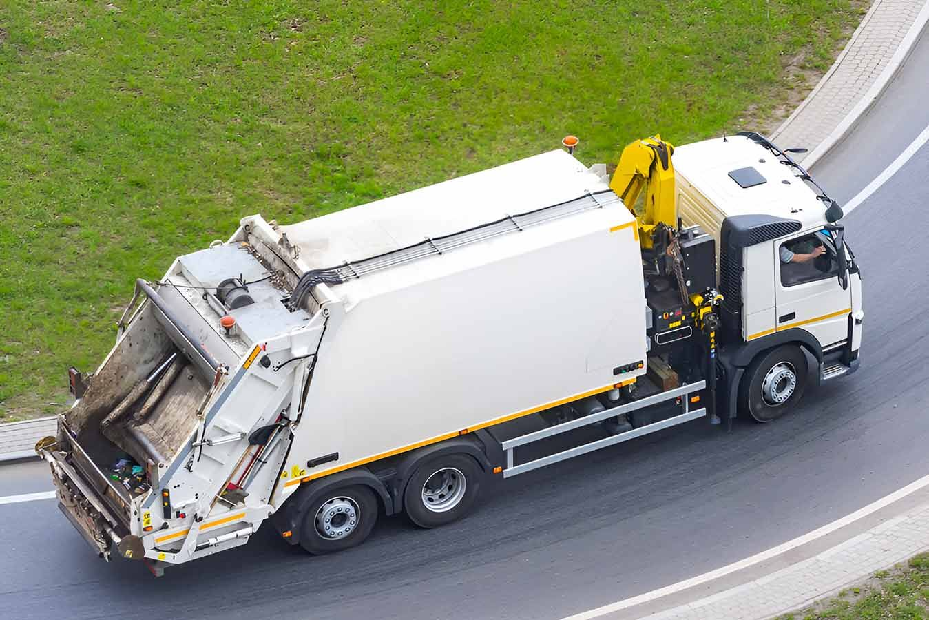 An Aerial View of a Garbage Truck Driving Down a Road — Truck Training and Assessments In Umina Beach, NSW