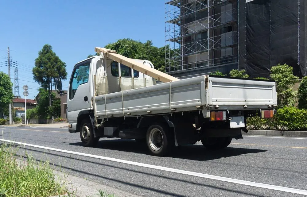 A White Truck is Driving Down a Street — Truck Training and Assessments In Umina Beach, NSW