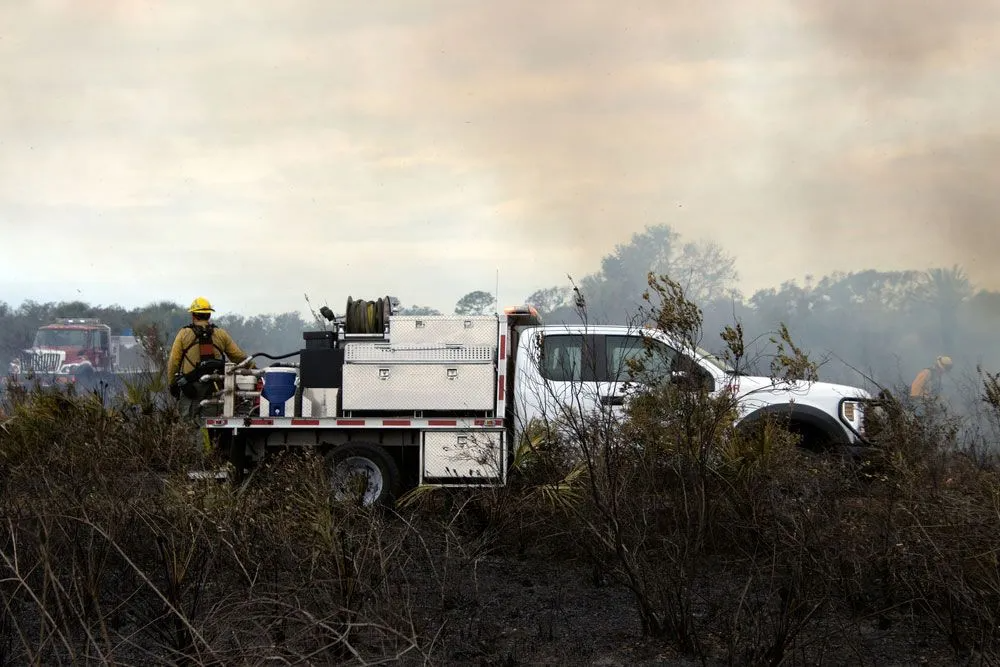 A Firefighter is Standing Next to a Truck in a Field — Truck Training and Assessments In Umina Beach, NSW