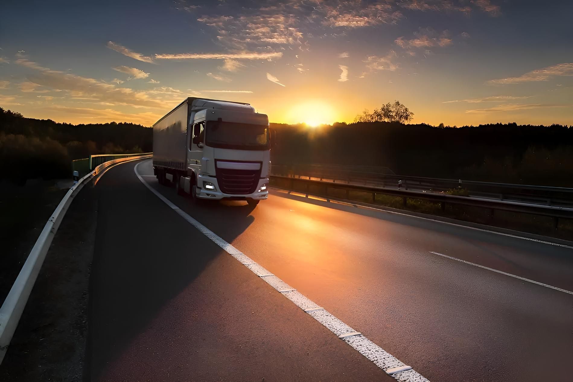 A Semi Truck is Driving Down a Highway at Sunset — Truck Training and Assessments In Umina Beach, NSW