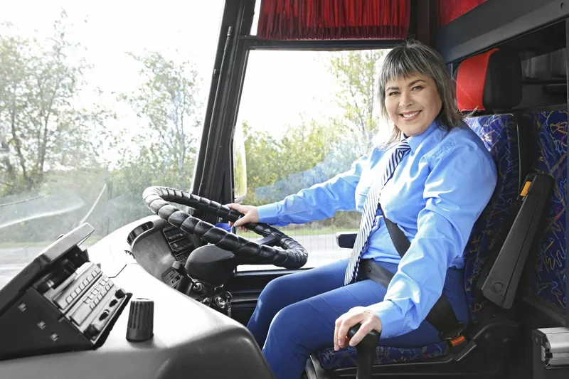 A Woman is Sitting in the Driver 's Seat of a Bus — Truck Training and Assessments In Umina Beach, NSW