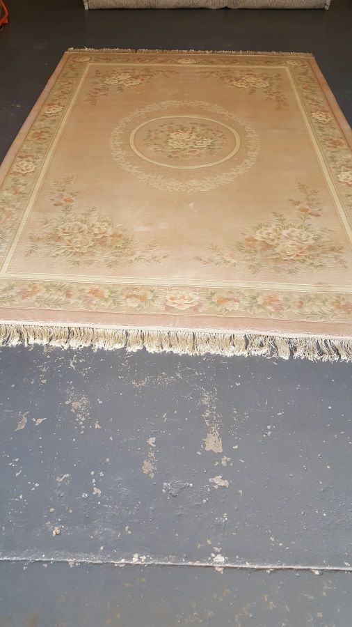 A rug is sitting on top of a concrete floor.