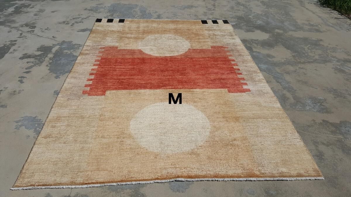 A rug with a red and white pattern is sitting on the ground.