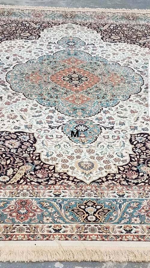 A rug with a pattern on it is sitting on a concrete floor.