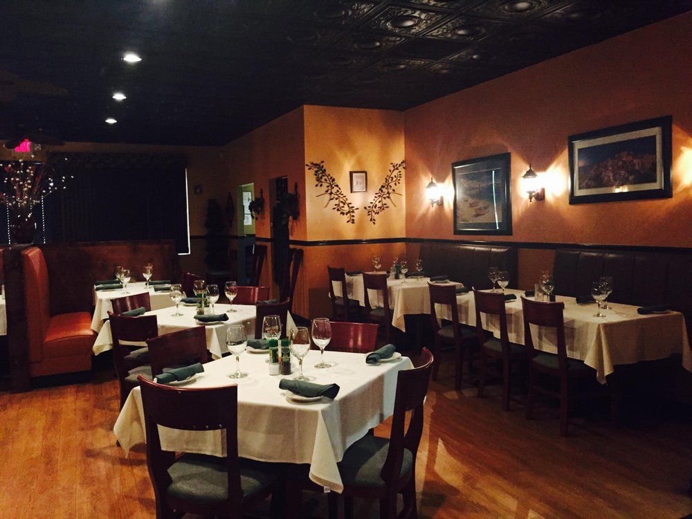 A dining room with tables and chairs and a picture on the wall for Misto by Chef Rocco