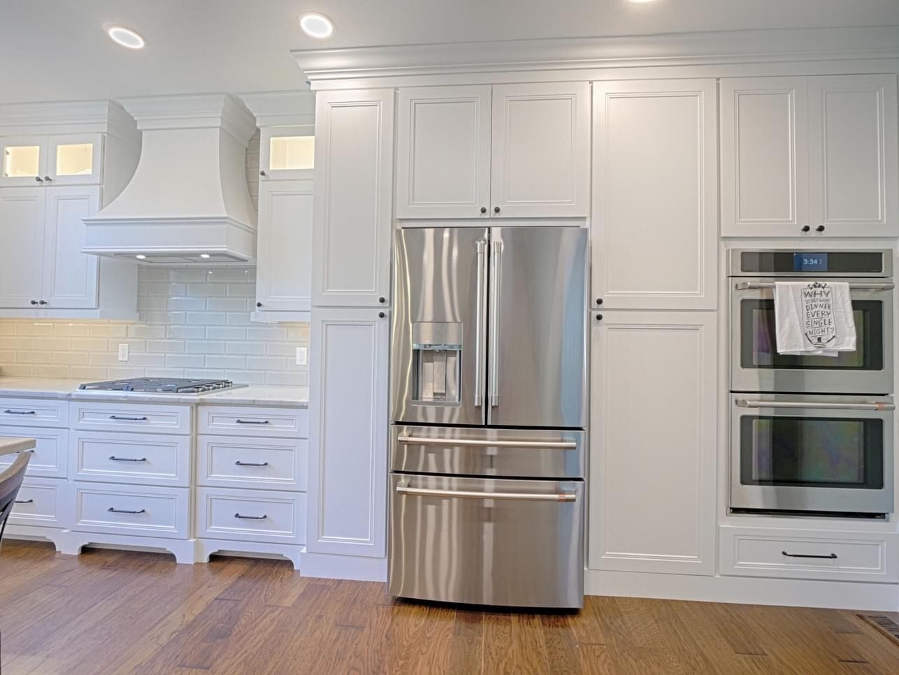 A kitchen with stainless steel appliances and white cabinets.