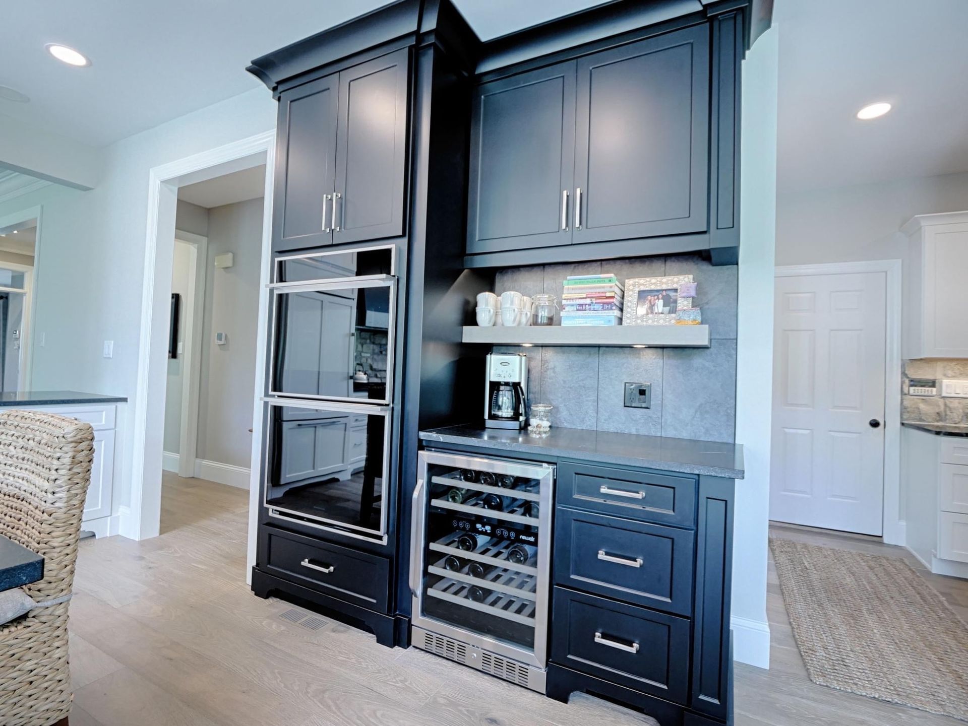 A kitchen with black cabinets and a wine cooler.