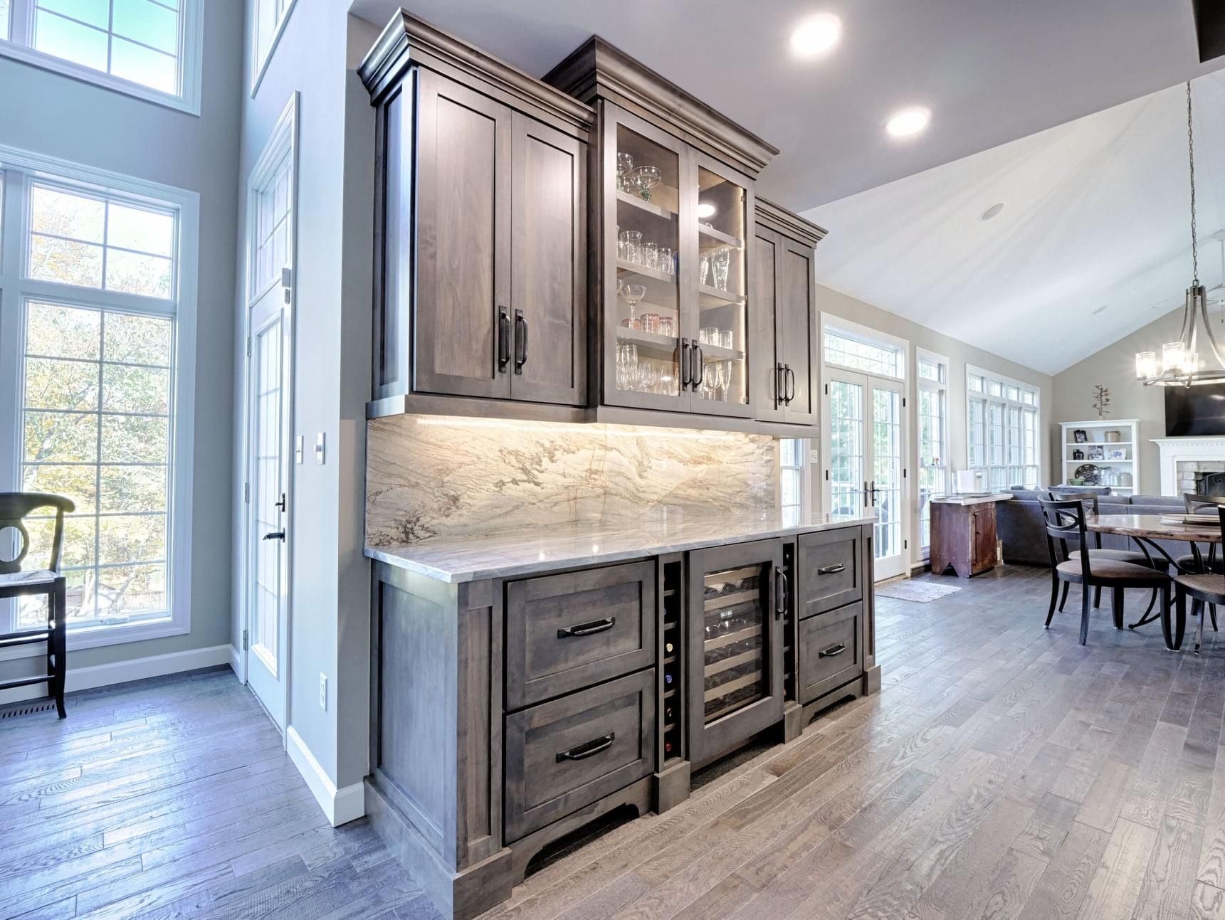 A kitchen with gray cabinets and a wine cooler.