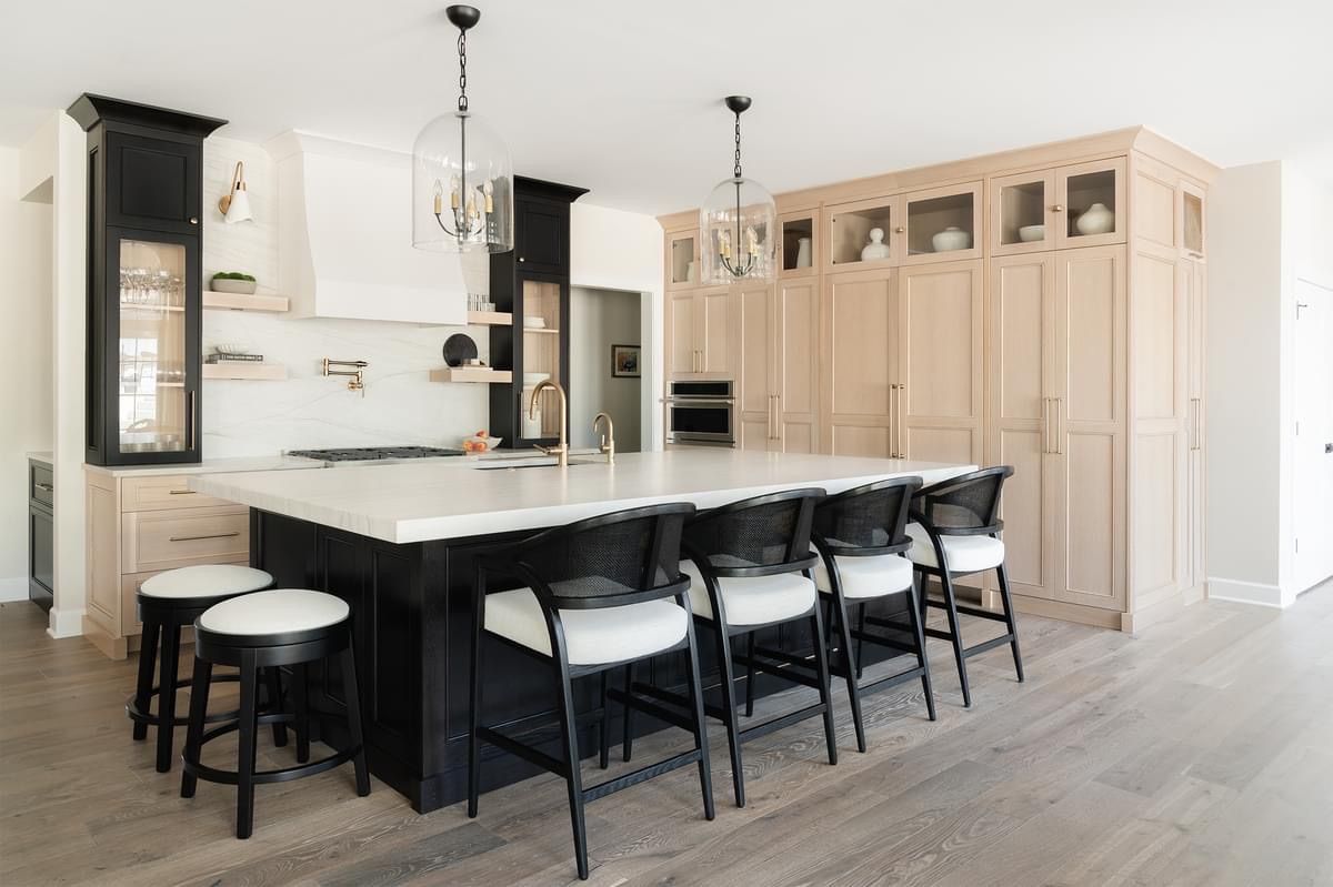 A kitchen with a large island and stools.