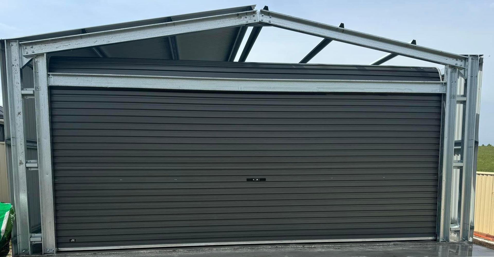 A large garage door with a metal frame and a roof.
