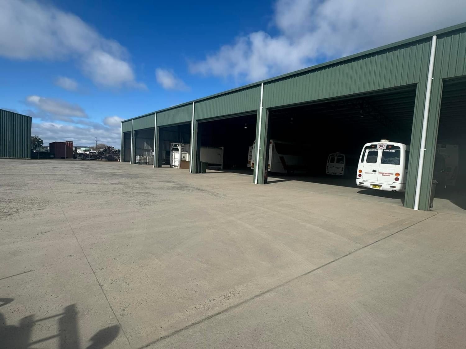 A man is standing in front of a garage door.
