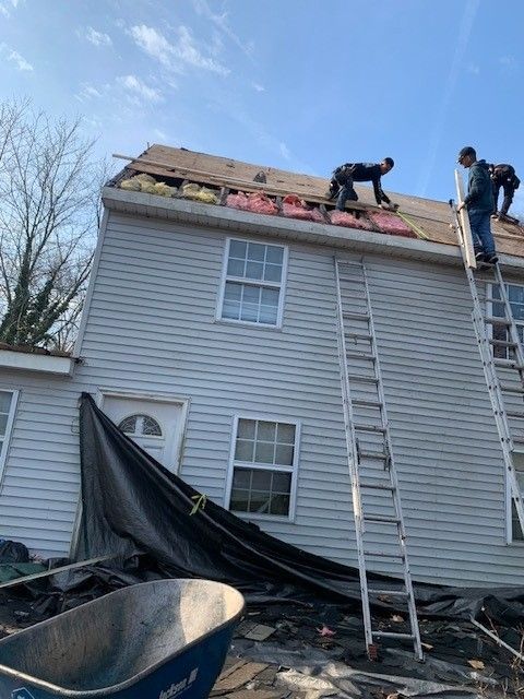 Affordable Roofing Services roofers repairing light gray home roof with ladder in cape may county, new jersey