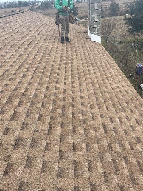 affordable roofing services roofer on brown shingle roof, performing roof maintenance in somers point, new jersey