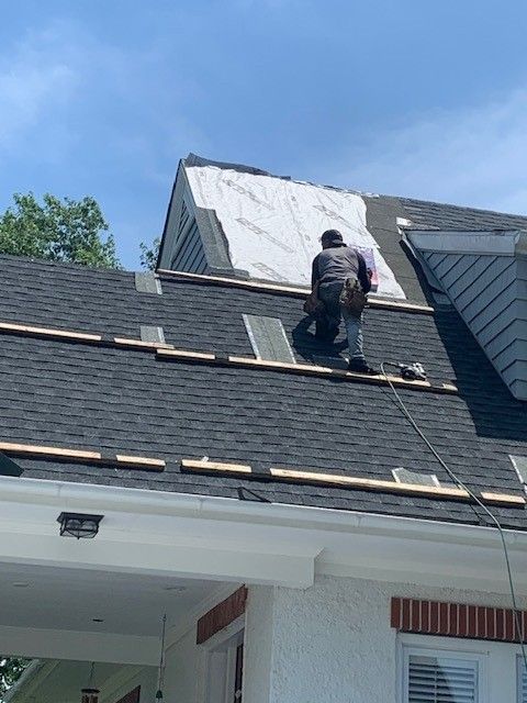 affordable roofing services roofer installing shingles on a sunny residential roof in galloway, new jersey
