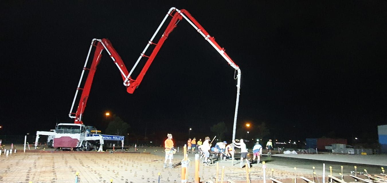 A Concrete Pump is Being Used to Pour Concrete at Night — Polley's Concrete Pumping in Kuttabul, QLD