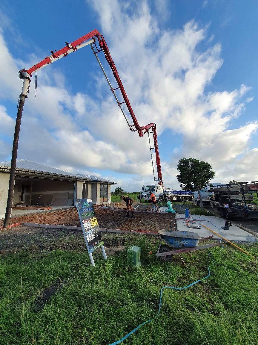A Concrete Pump is Pumping Concrete Into a Hole in the Ground — Polley's Concrete Pumping in Rural View, QLD