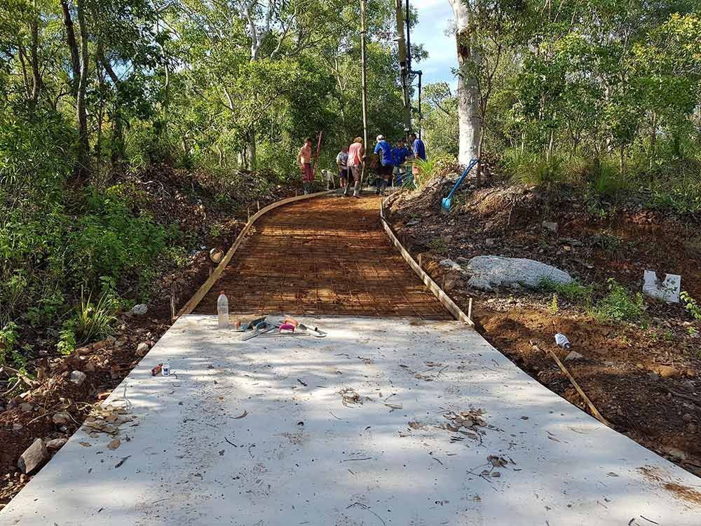 A Group of People Are Walking Down a Concrete Path in the Woods — Polley's Concrete Pumping in Sarina, QLD