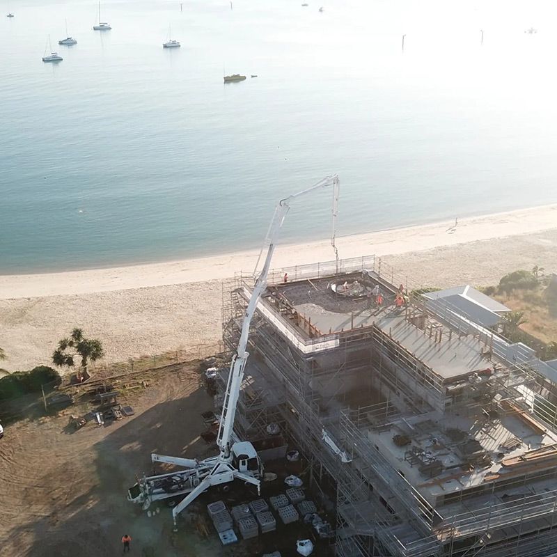 An Aerial View of a Building Under Construction Next to the Ocean — Polley's Concrete Pumping in Moranbah, QLD