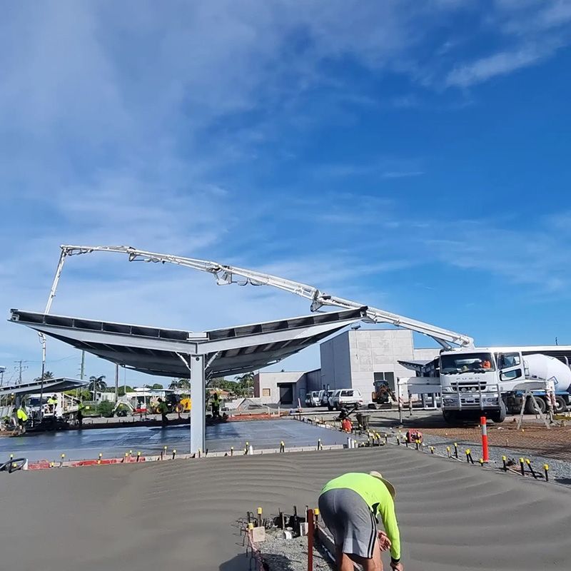 A Man in a Neon Green Shirt is Working on a Concrete Surface — Polley's Concrete Pumping in Kuttabul, QLD