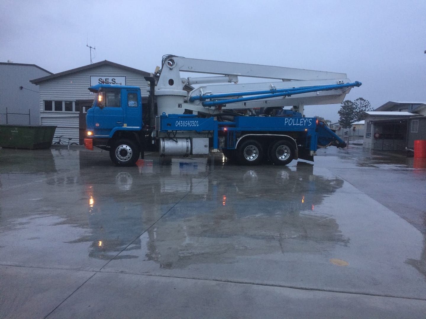 A Blue and White Concrete Pump Truck is Parked in a Parking Lot — Polley's Concrete Pumping in Marian, QLD