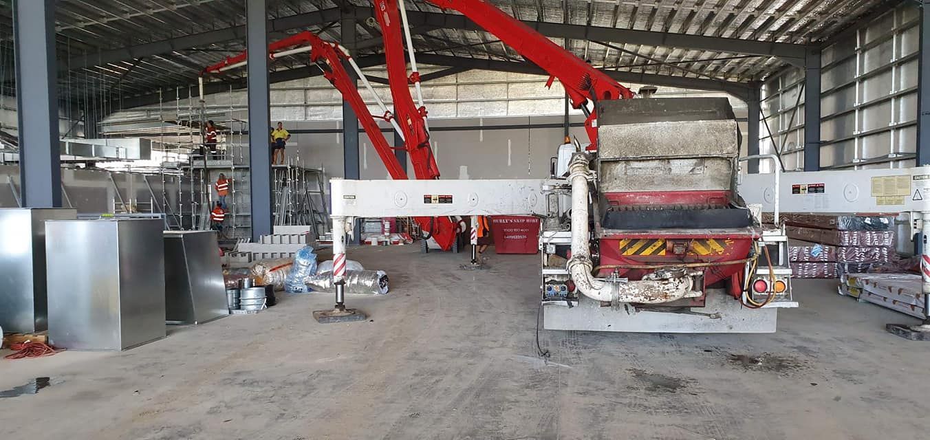A Large Warehouse With a Lot of Machinery in It — Polley's Concrete Pumping in Marian, QLD