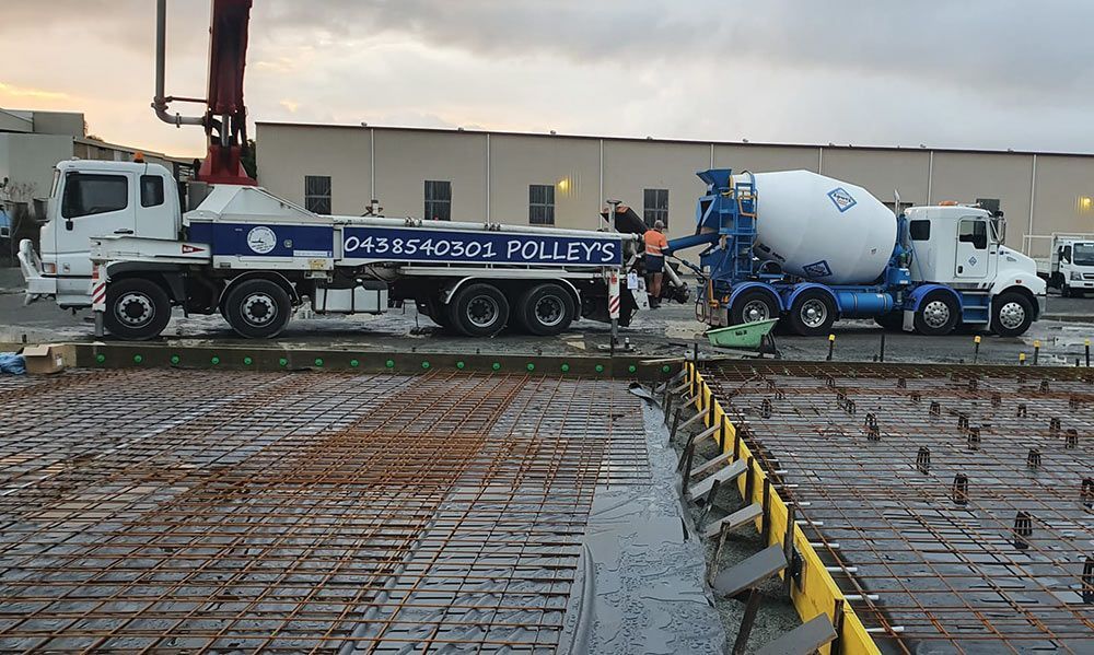A Concrete Pump Truck is Being Used to Pump Concrete Into a Concrete Slab — Polley's Concrete Pumping in Marian, QLD