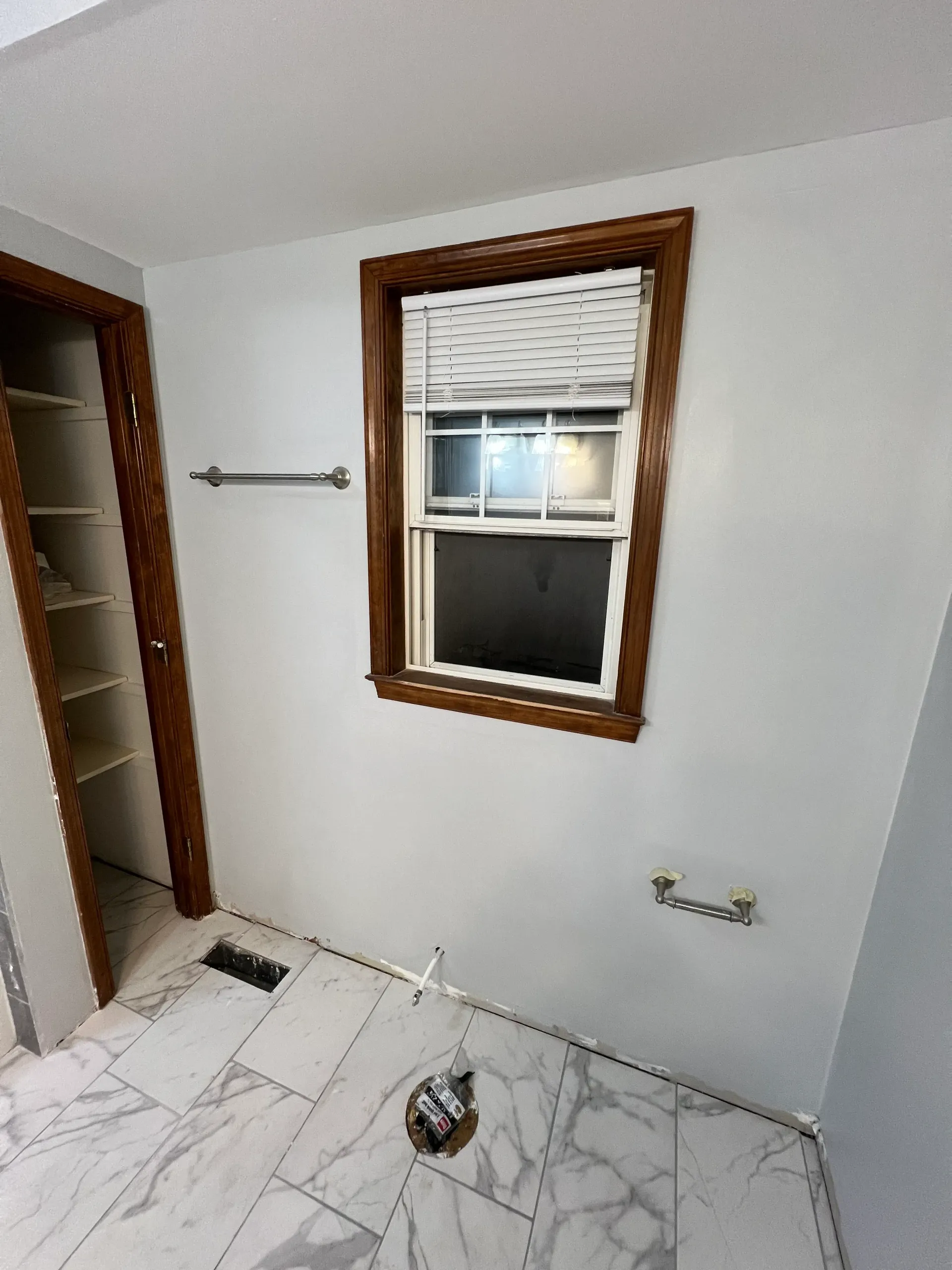 A bathroom with a window and a toilet.